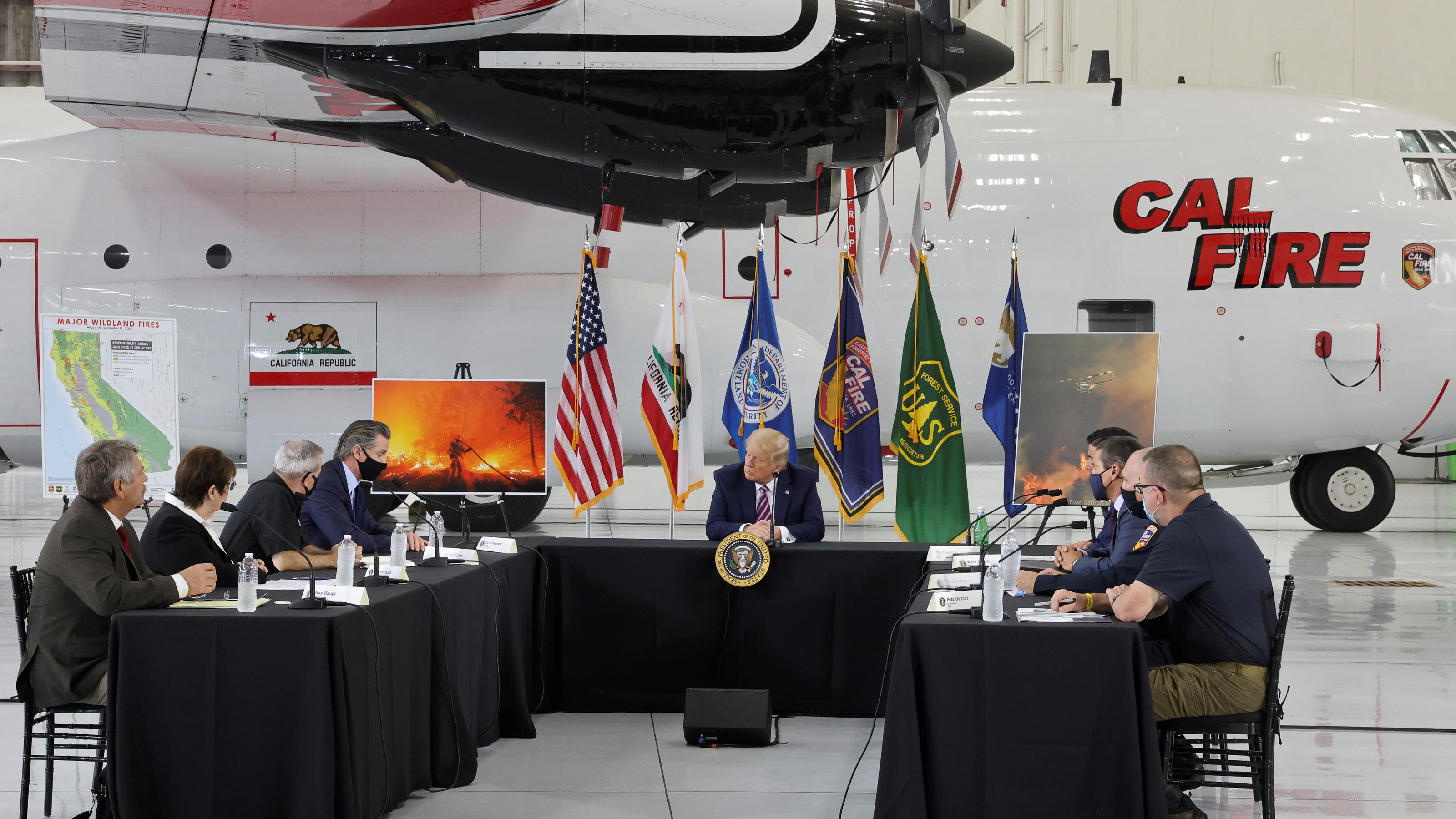 Waldbrände in Kalifornien und Klimawandel: Donald Trumps Aussagen im Faktencheck U.S. President Donald Trump sits in front of a CAL FIRE firefighting aircraft as California Governor Gavin Newsom speaks during a briefing on wildfires in McClellan Park, California, U.S., September 14, 2020. REUTERS/Jonathan Ernst