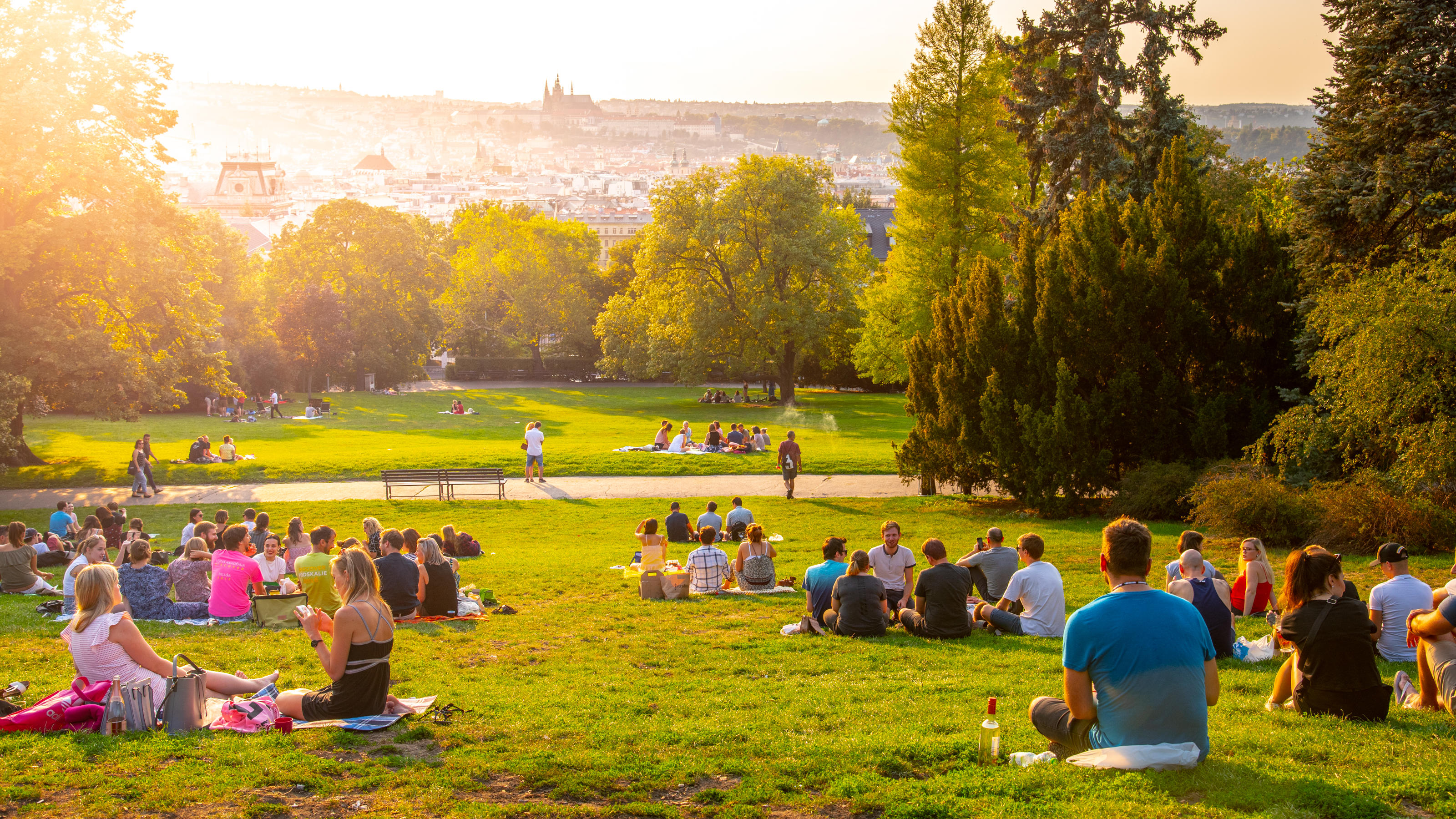 Das Wetter am Sonntag genießen - ein Knaller-Spätsommer-Tag! PRAGUE, CZECH REPUBLIC - AUGUST 17, 2018: Sunset in Rieger Gardens, Riegrovy sady, in Prague. Many people sitting in the grass and enjoying sunny summer evening and lookout of Prague historical city centre. Czech Republic.
