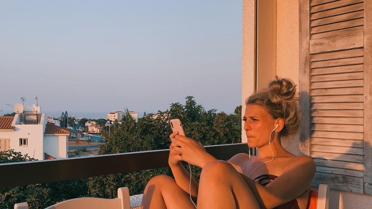 Quarantäne-Chaos auf Zypern: Paar erlebt blanken Wahnsinn statt purer Erholung Frau sitzt auf Balkon im roten Abendlicht