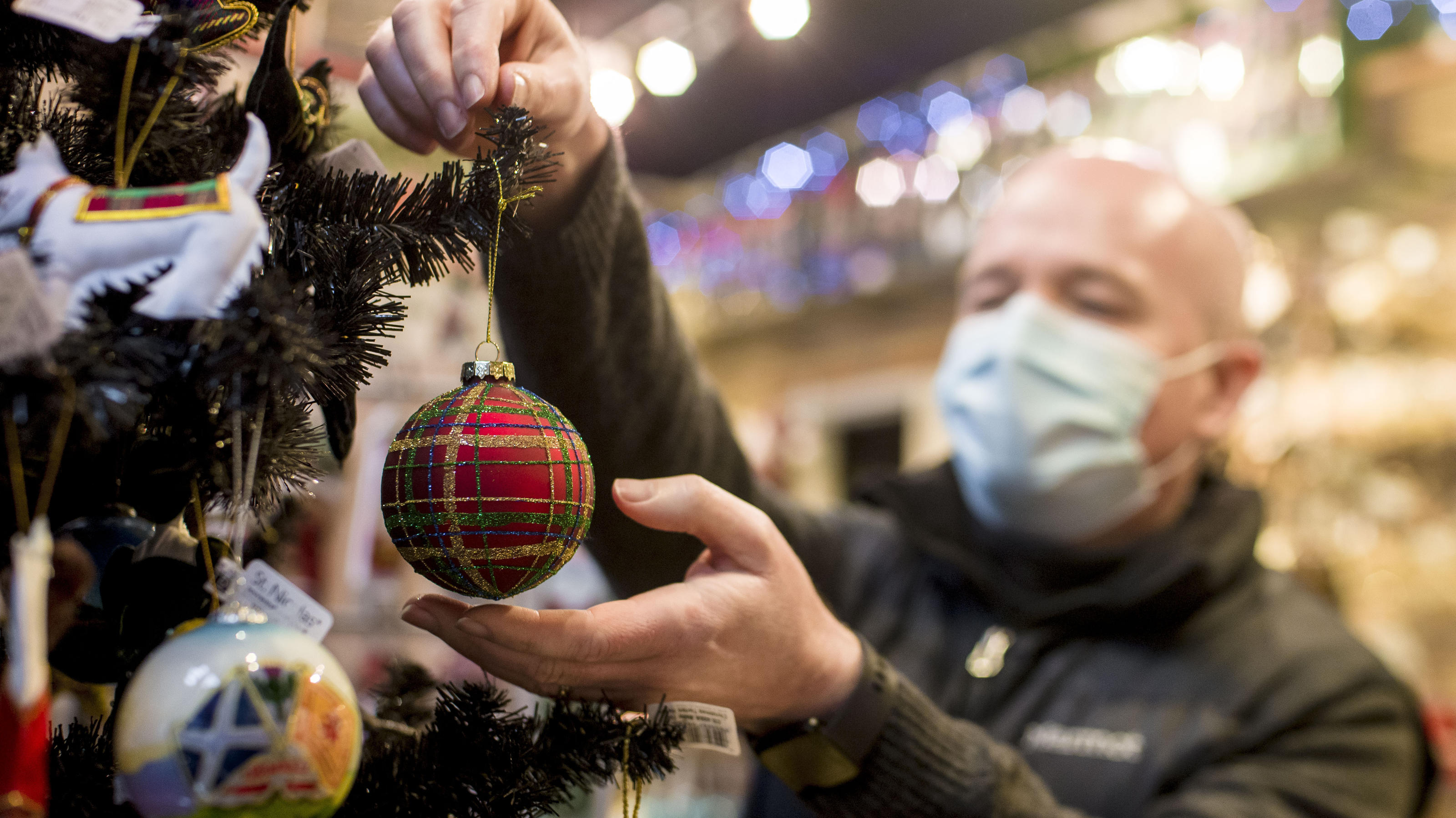 Erstes Land Europas sagt Chris Smyth owner of Ye Olde Christmas Shoppe in Edinburgh hangs a decoration on a Christmas tree in his shop, as Mr Leitch said people should