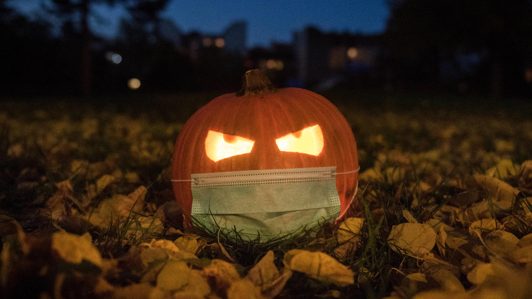 Wie sich das Wetter auf das Coronavirus auswirkt Ein Kürbis mit einem Mundschutz liegt für eine Fotoillustration im Herbstlaub. Herbst Kürbis mit Mundschutz *** A pumpkin with a mouthguard lies in the autumn foliage for a photo illustration Autumn pumpkin with mouthguard