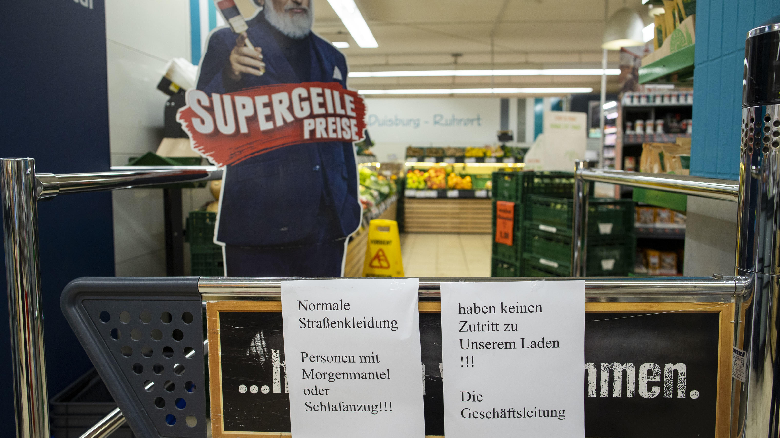 Einkaufen im Pyjama verboten! Marktleiter schmeißt Mutter und Kind raus Auf einem Schild am Markteingang steht