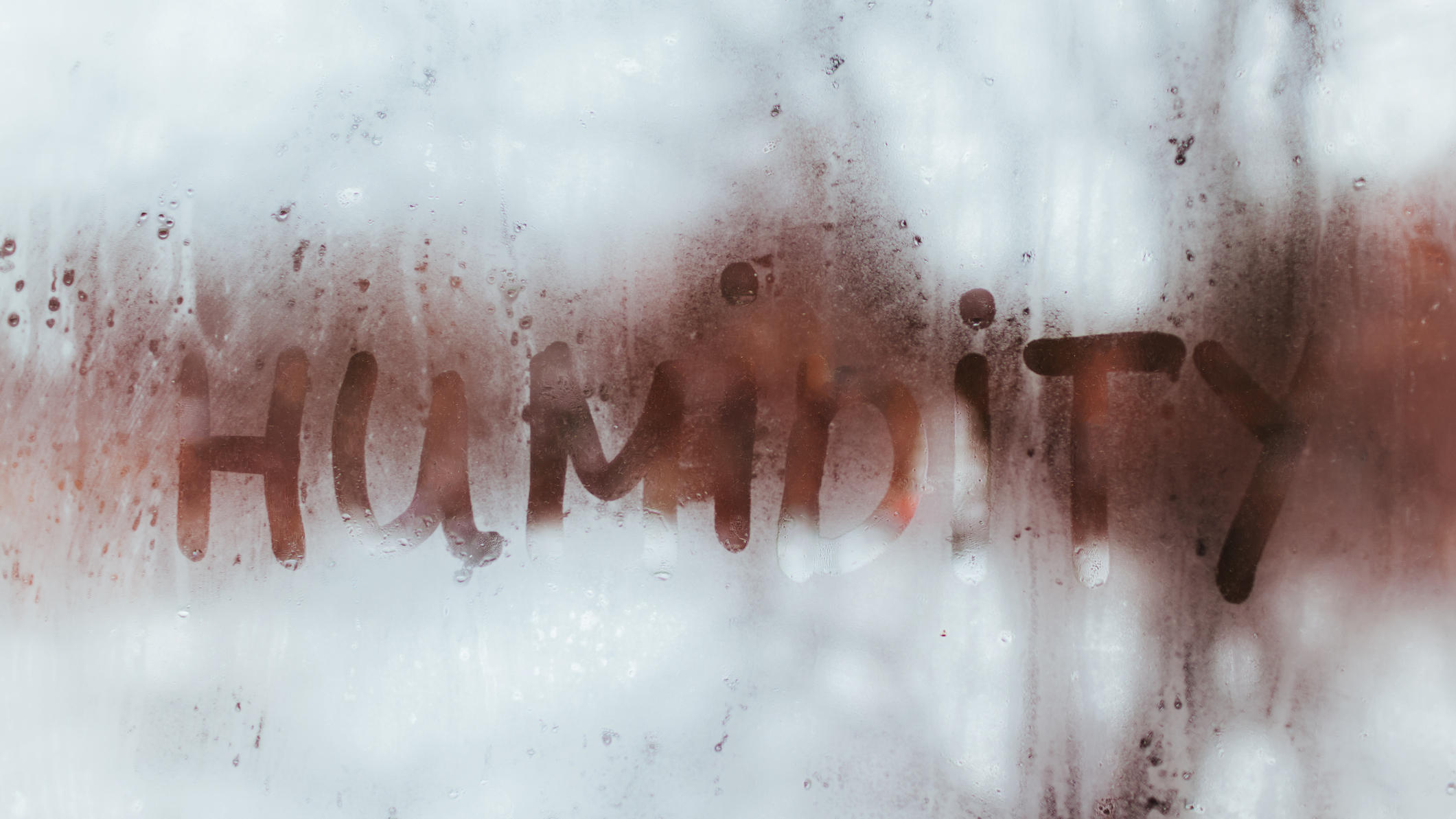 Geblendet durch tief stehende Sonne – das hilft Humidity word written on wet window with condensate. High level of dampness in apartment.