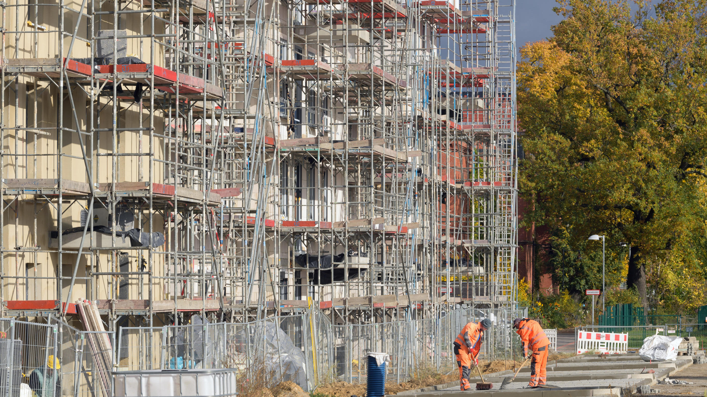 ex-Eta dreht auf: Tropensturm wird zum Wintersturm ARCHIV - 29.10.2020, Brandenburg, Potsdam: Zwei Arbeiter verteilen vor den Rohbauten der Häuser an der Peter-Huchel-Straße Erde am Rand der künftigen Straße. Anders als in vielen anderen Branchen laufen die Geschäfte auf dem Bau vorerst weiter stabil