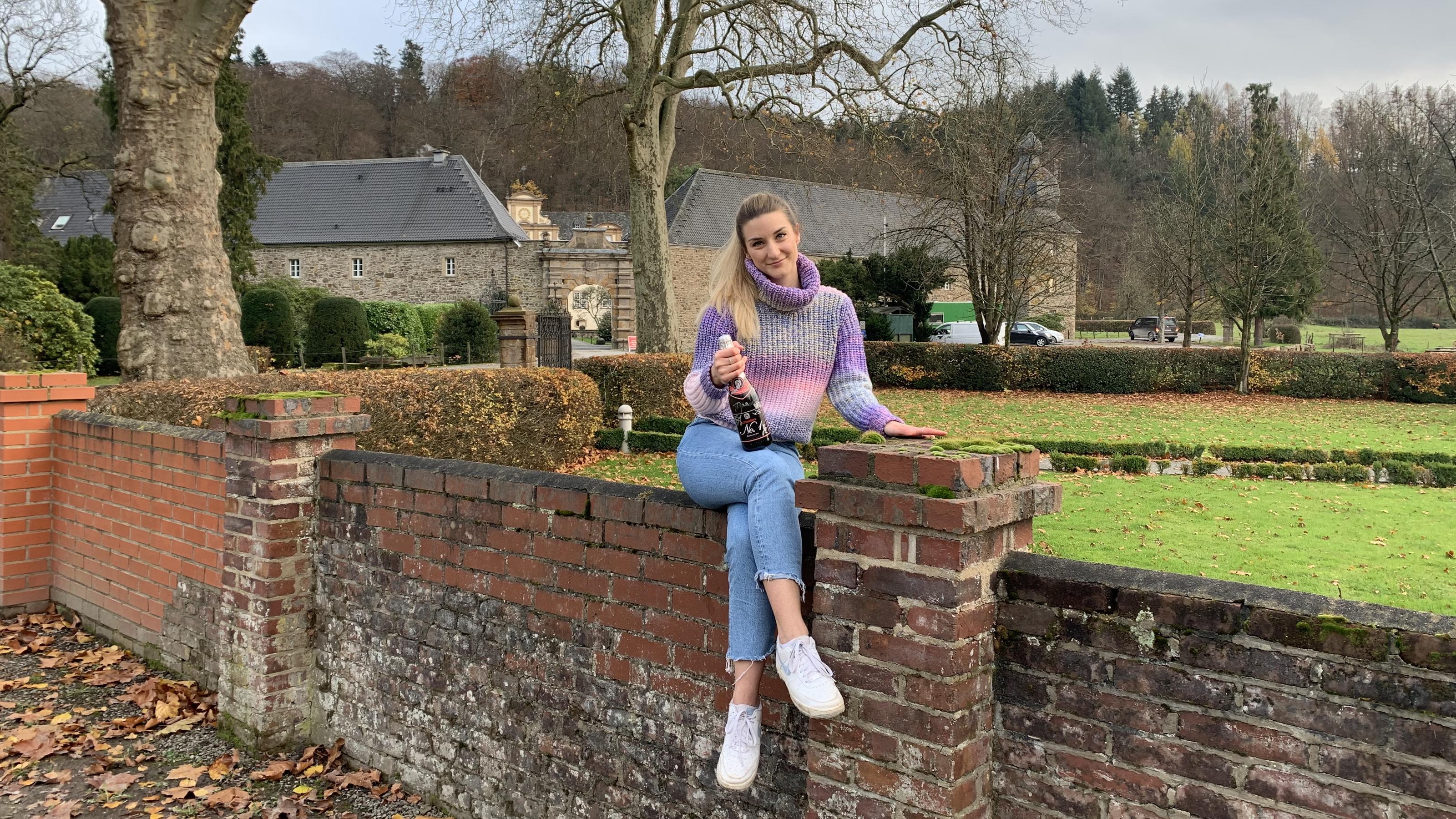 Wieso ein Soap-Kuss fast mein berufliches Leben verändert hätte Daria Bücheler sitzt auf einer Mauer vor dem Soap-Schloss