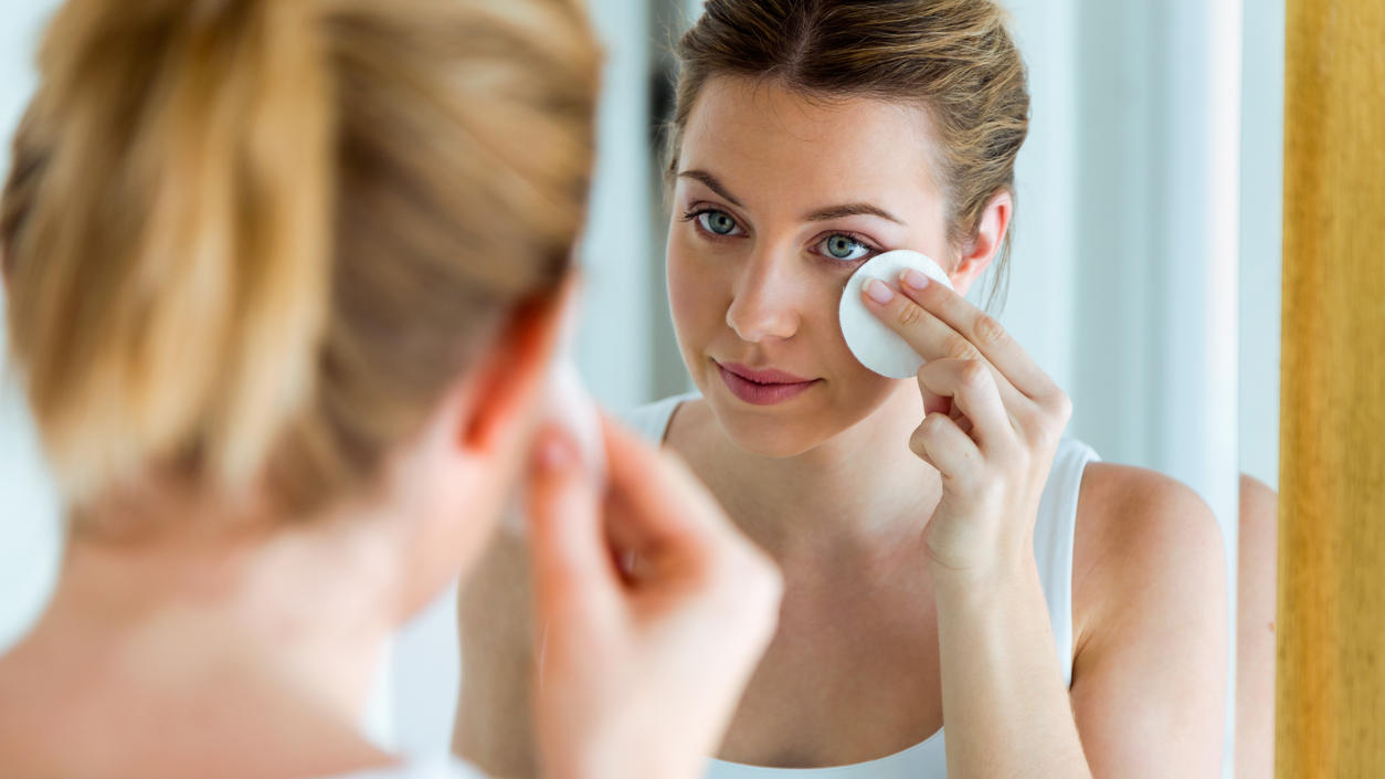 Öko-Test: Diese günstigen Augen-Make-up-Entferner sind „sehr gut“ Junge Frau schminkt sich mit Wattepad ab