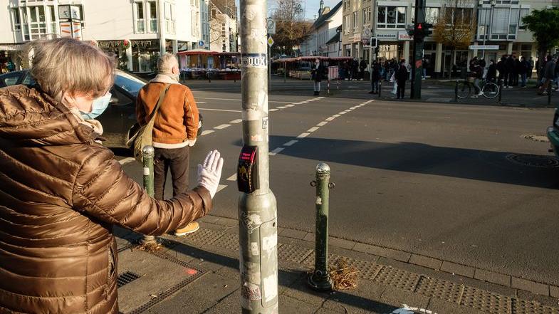 Ampeln ohne Ansteckungsrisiko: In Düsseldorf muss man jetzt nicht mehr drücken Tritt, wie im Bild, ein Fußgänger näher an den Taster heran, löst er die Anforderung, dass es