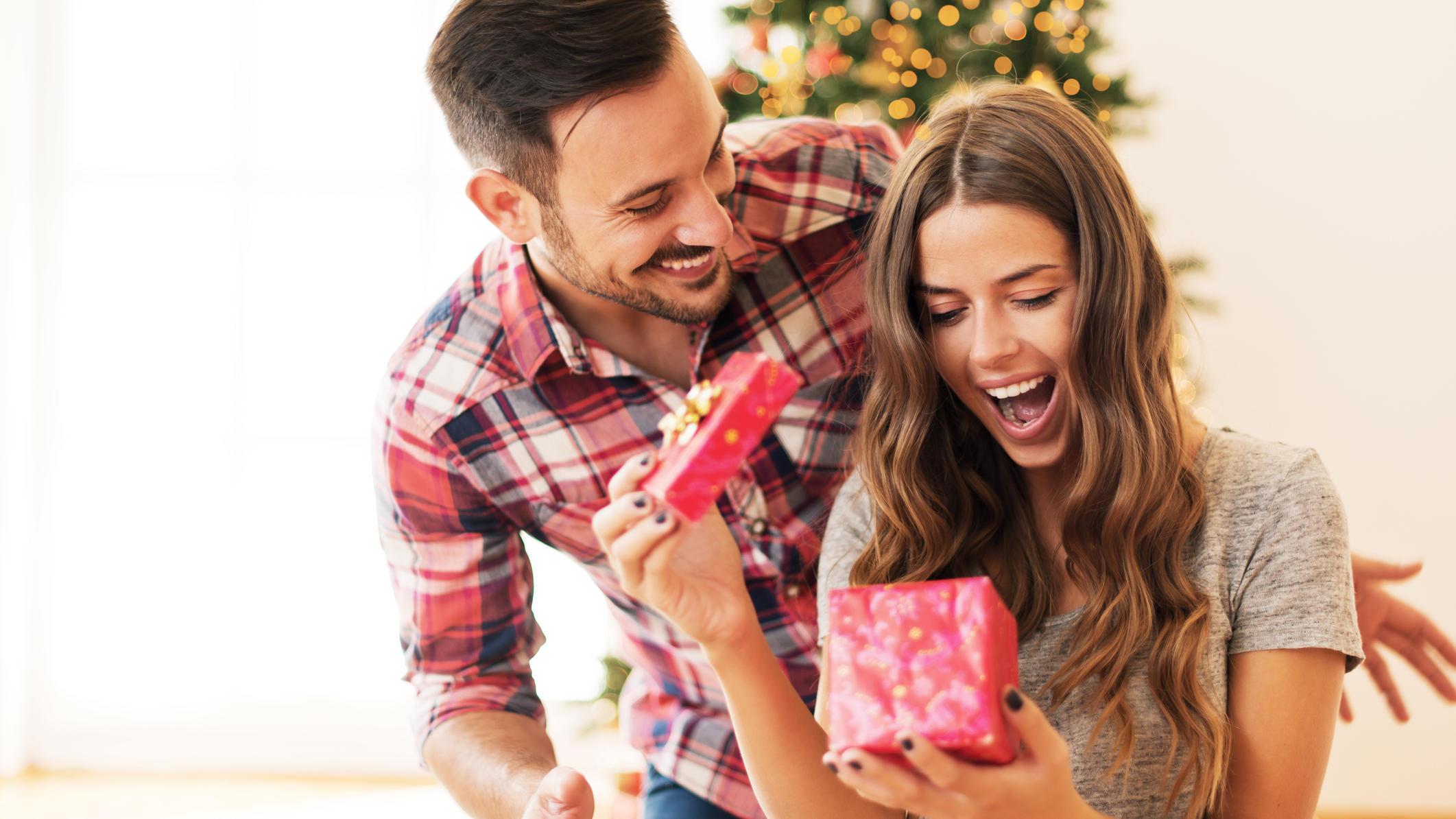 Jeder Vierte setzt auf gebrauchte Weihnachtsgeschenke Frau freut sich über gebrauchtes Weihnachtsgeschenk ihres Freundes.