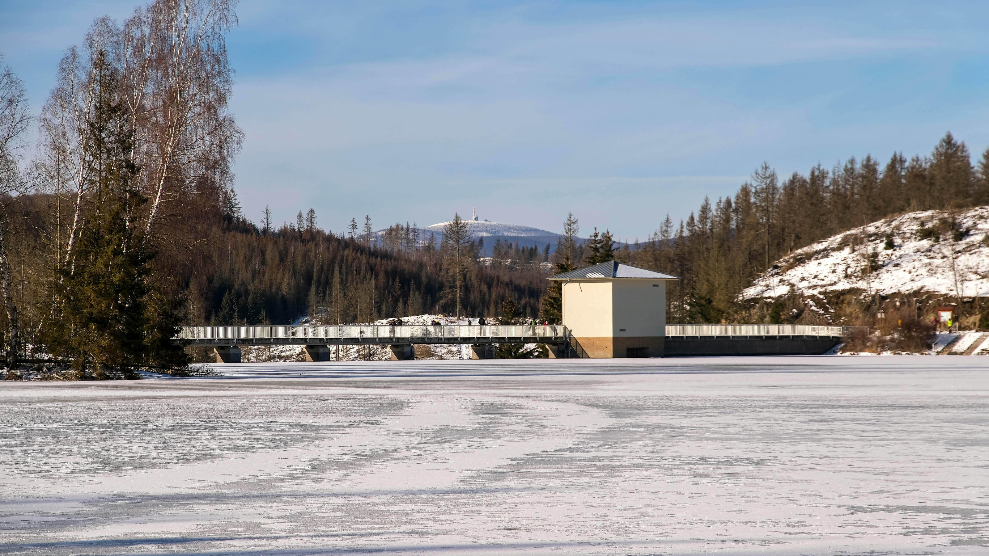 Deshalb ist der Winter 2021 ein gutes Beispiel für den Klimawandel Die Wasserfläche der Talsperre Hassel im Landkreis Harz in Sachsen-Anhalt mit dem Wahrzeichen und höchstem Berg des Harzes, dem Brocken.