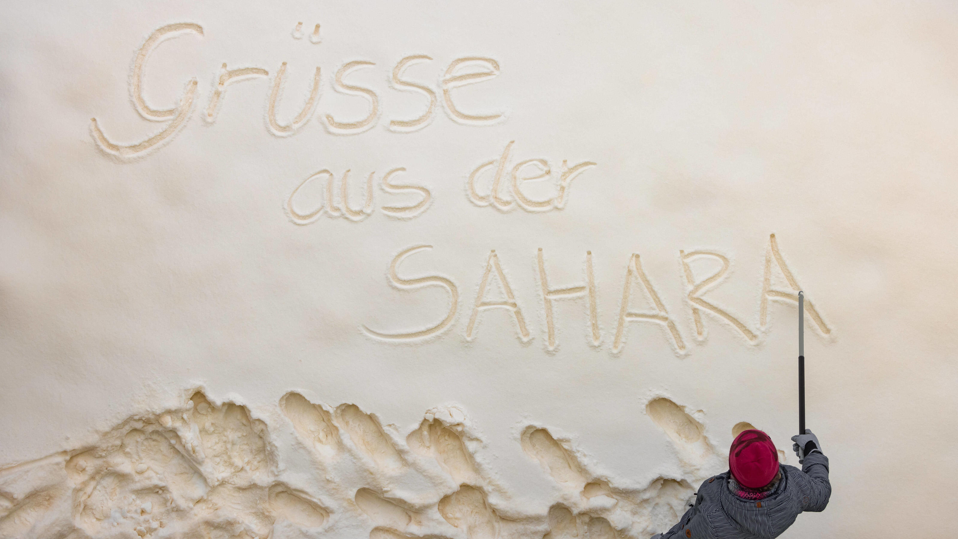 Zwei Tote im Schnee entdeckt ++++ Dach von Holzfachhandel eingestürzt Blutschnee mit Sandstaub aus der Sahara Eine Frau schreibt Grüße aus der Sahara in den Schnee. Der gelb-orange Sandstaub aus der Sahara ist für den Blutschnee - Effekt verantwortlich. Ilmenau Thüringen DEUTSCHLAND *** Blood snow with sand dust from