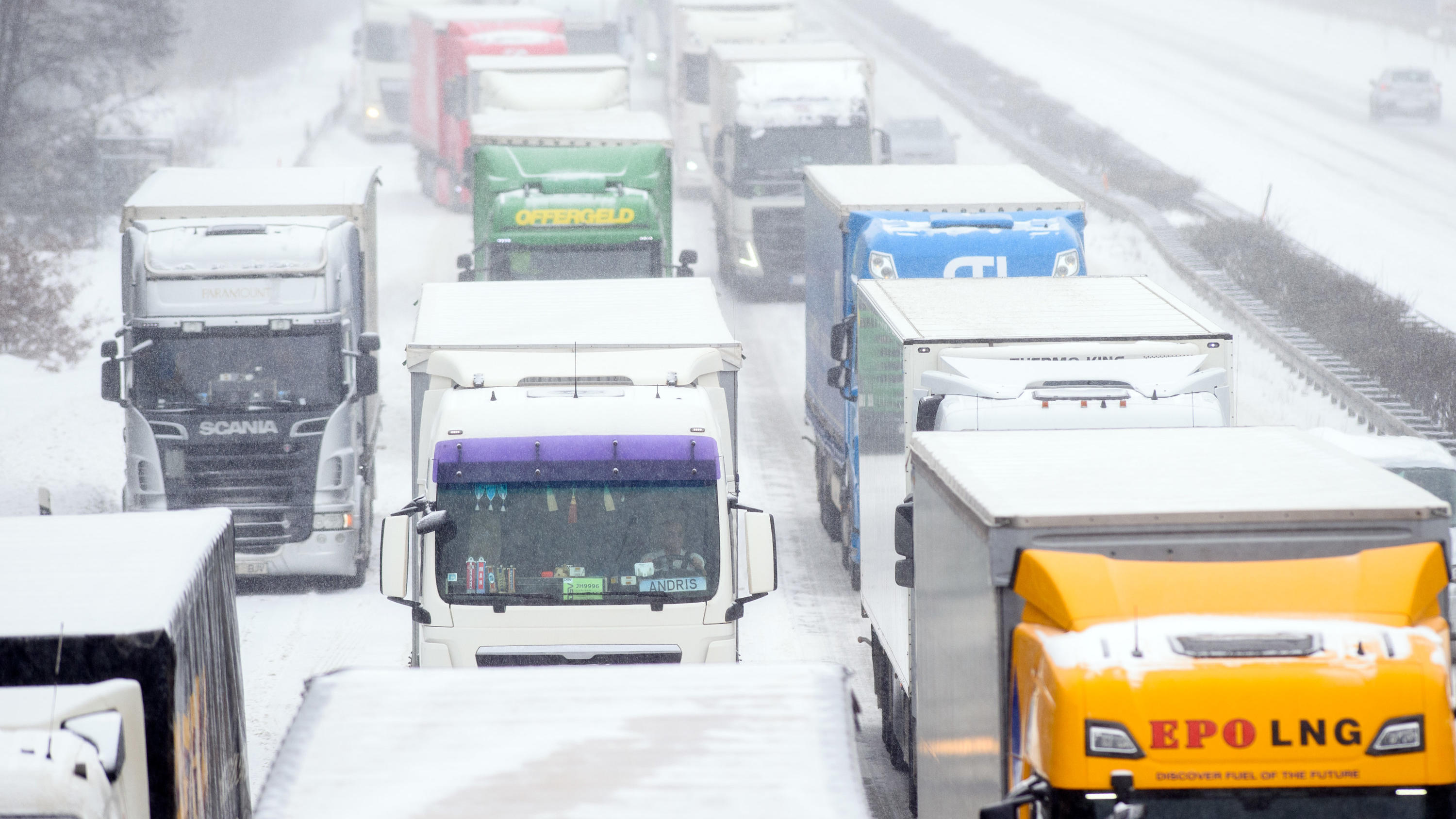 Zwei Tote im Schnee entdeckt ++++ Dach von Holzfachhandel eingestürzt 08.02.2021, Sachsen-Anhalt, Möckern: Lastwagen stauen sich auf der A2 an einer Unfallstelle. Bei frostigen Temperaturen kann es den ganzen Tag immer wieder schneien. Foto: Klaus-Dietmar Gabbert/dpa-Zentralbild/dpa +++ dpa-Bildfunk +++