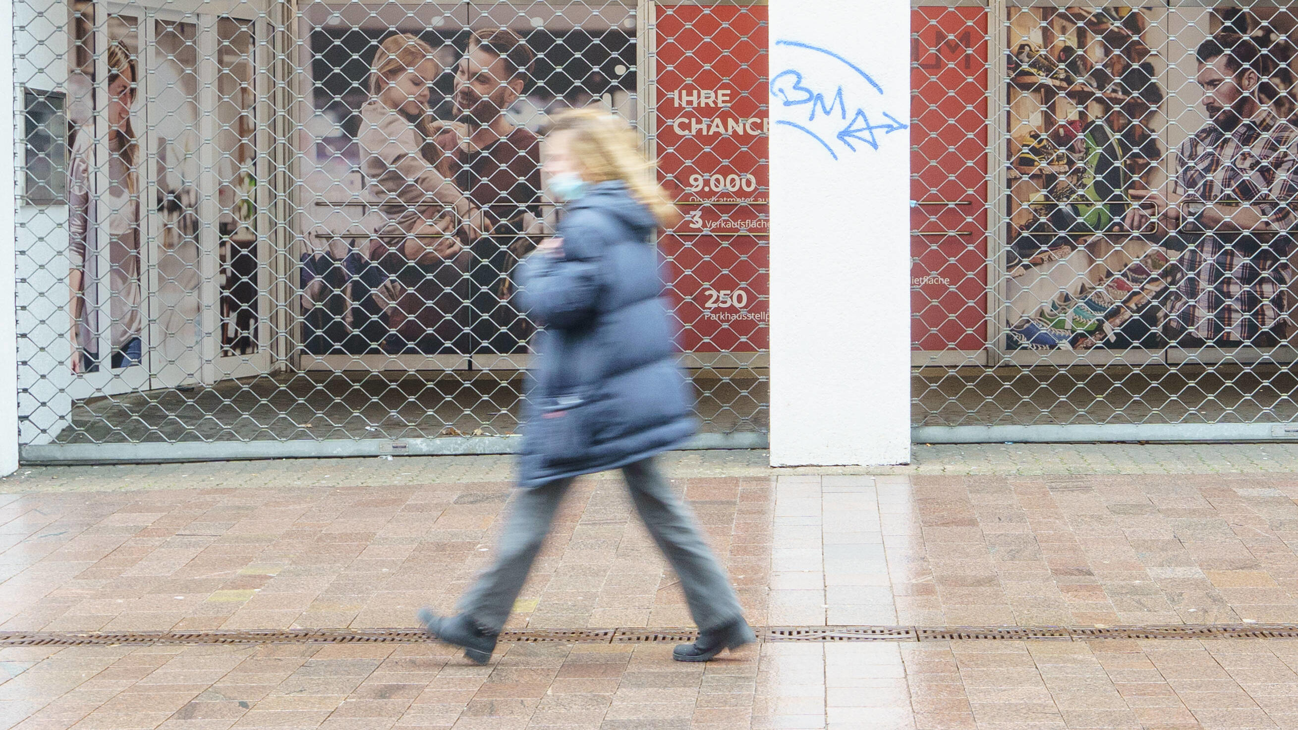 Schutz vor Coronavirus: Schwächen wir damit unser Immunsystem? Die Flensburger Innenstadt ist im Zuge der Coronavirus-Pandemie zum Hochinzidenzgebiet erklärt worden, man sieht eine einzige Frau, wie sie mit Mund-Nasen-Schutz-Maske an einem geschlossenen Laden vorbeigeht.