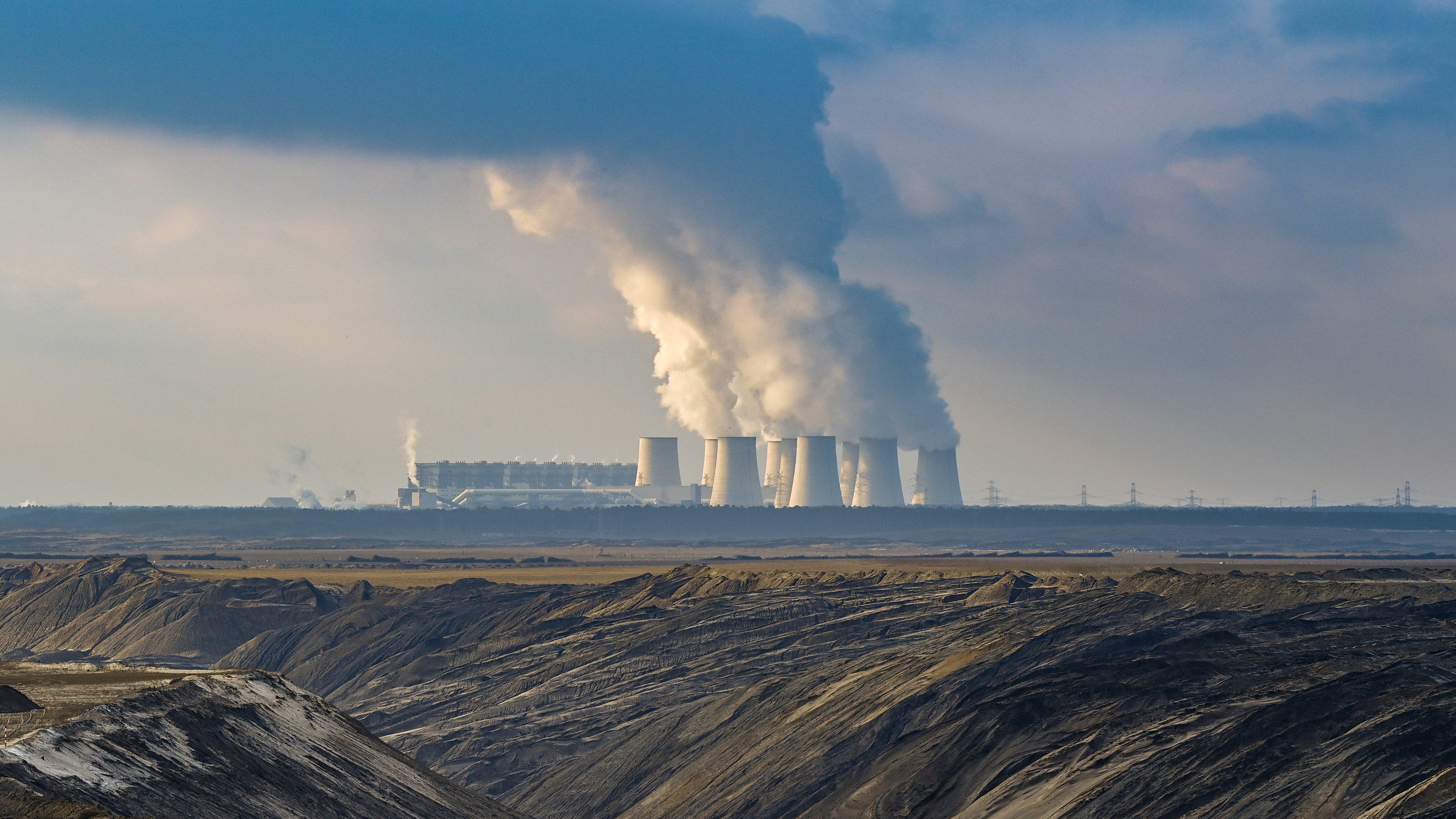 Nachhaltigkeitsrevolution, um Klimawandel zu stoppen Wasserdampf steigt aus den Kühltürmen des Braunkohlekraftwerkes Jänschwalde. Im Vordergrund der Braunkohletagebau Jänschwalde