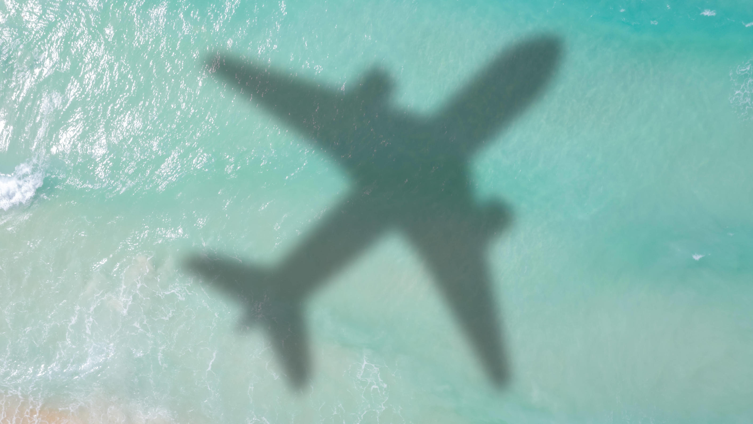 Großbritannien plant Impfpass, damit geimpfte Bürger bald problemlos reisen können Ein Flugzeug fliegt übers Meer. Ein Impfpass soll geimpften Briten internationale Reisen ermöglichen.