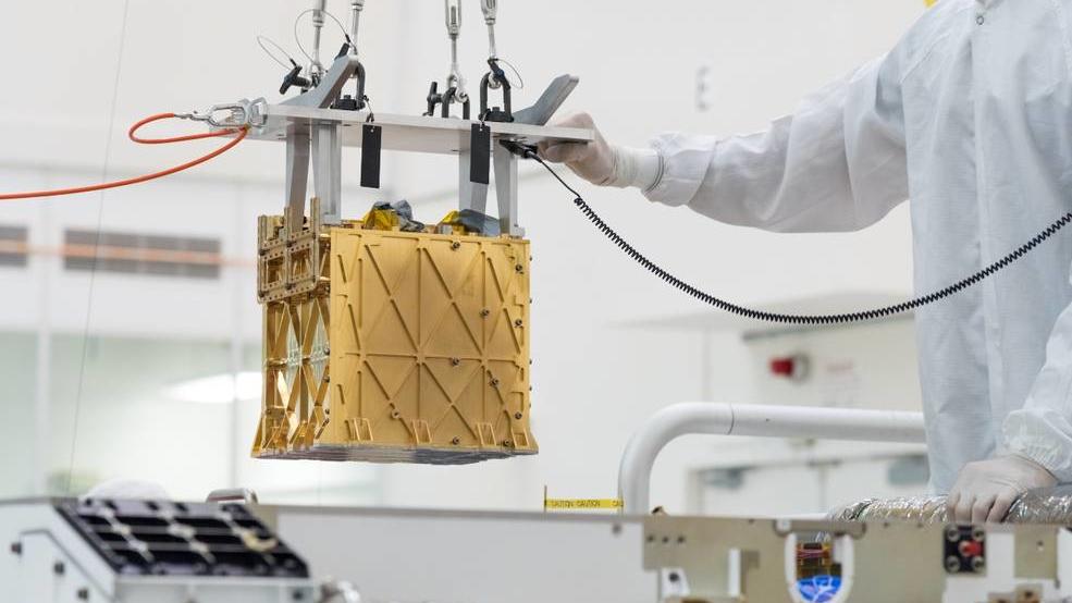 Leben auf dem Mars: Mars-Rover „Perseverance“ extrahiert erstmals Sauerstoff HANDOUT - 21.04.2021, USA, --: Techniker in einem Nasa-Labor führen das wissenschaftlichen Gerät namens «Moxie» (Mars Oxygen In-Situ Resource Utilization Experiment) von der Größe eines Toasters in das Innere des Mars-Rover «Perseverance» ein (undati