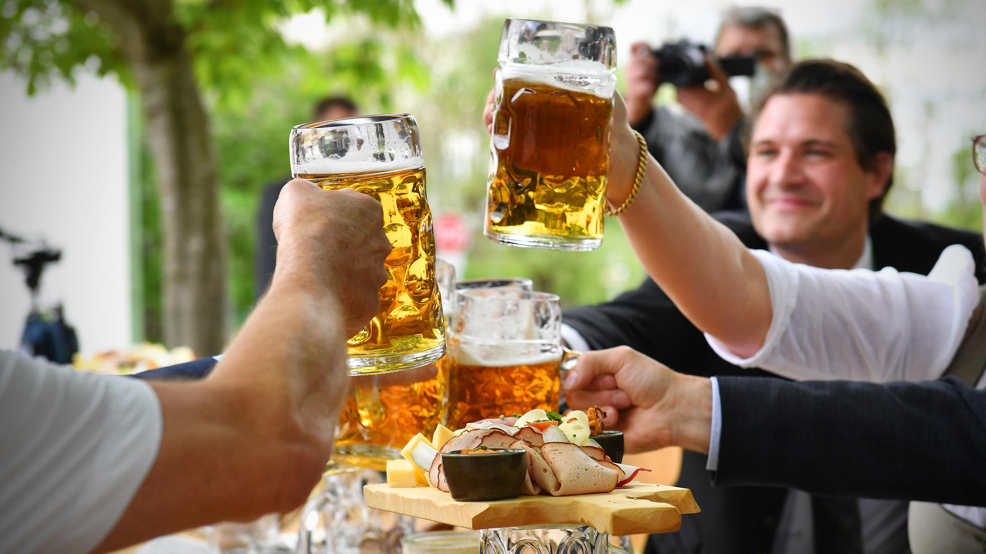 Diese Corona-Regeln gelten am Vatertag Drei Menschen stoßen mit Bierkrügen an.