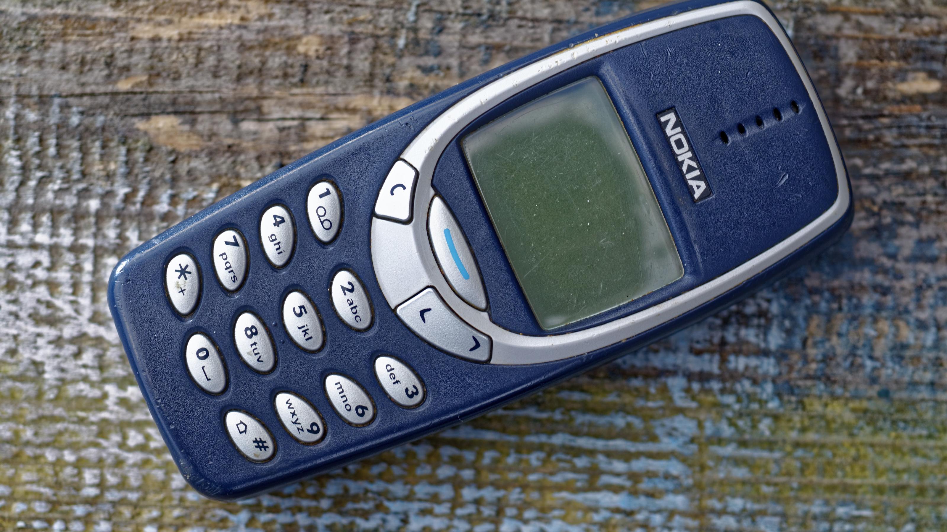 Diese Uralt-Handys sind heute verdammt viel wert Ein Nokia 3310-Handy liegt auf einem Holz-Untergrund.