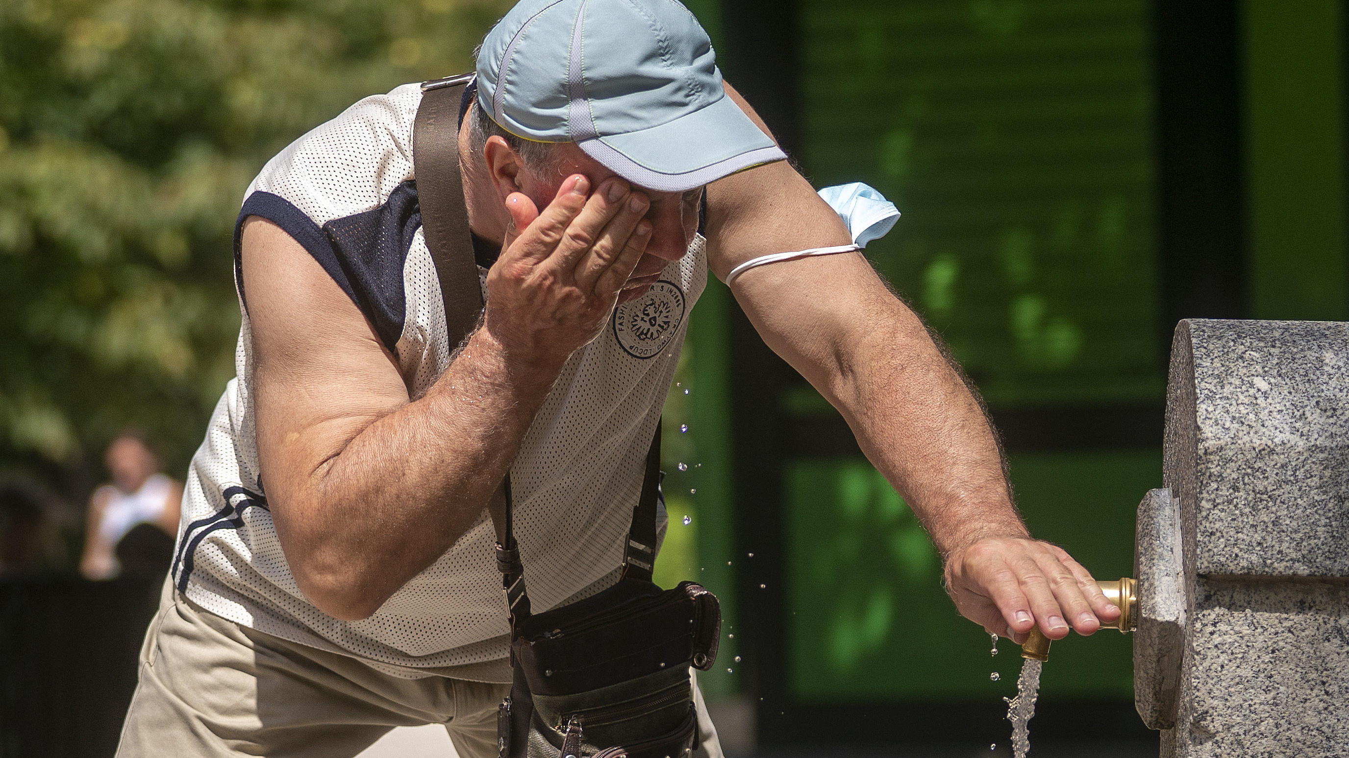 Kinder von heute werden bis zu siebenmal mehr Extremwetter erleben als ihre Großeltern 12.08.2021, Spanien, Madrid: Ein Mann versucht, sich in einem Brunnen im Retiro-Park in Madrid abzukühlen.