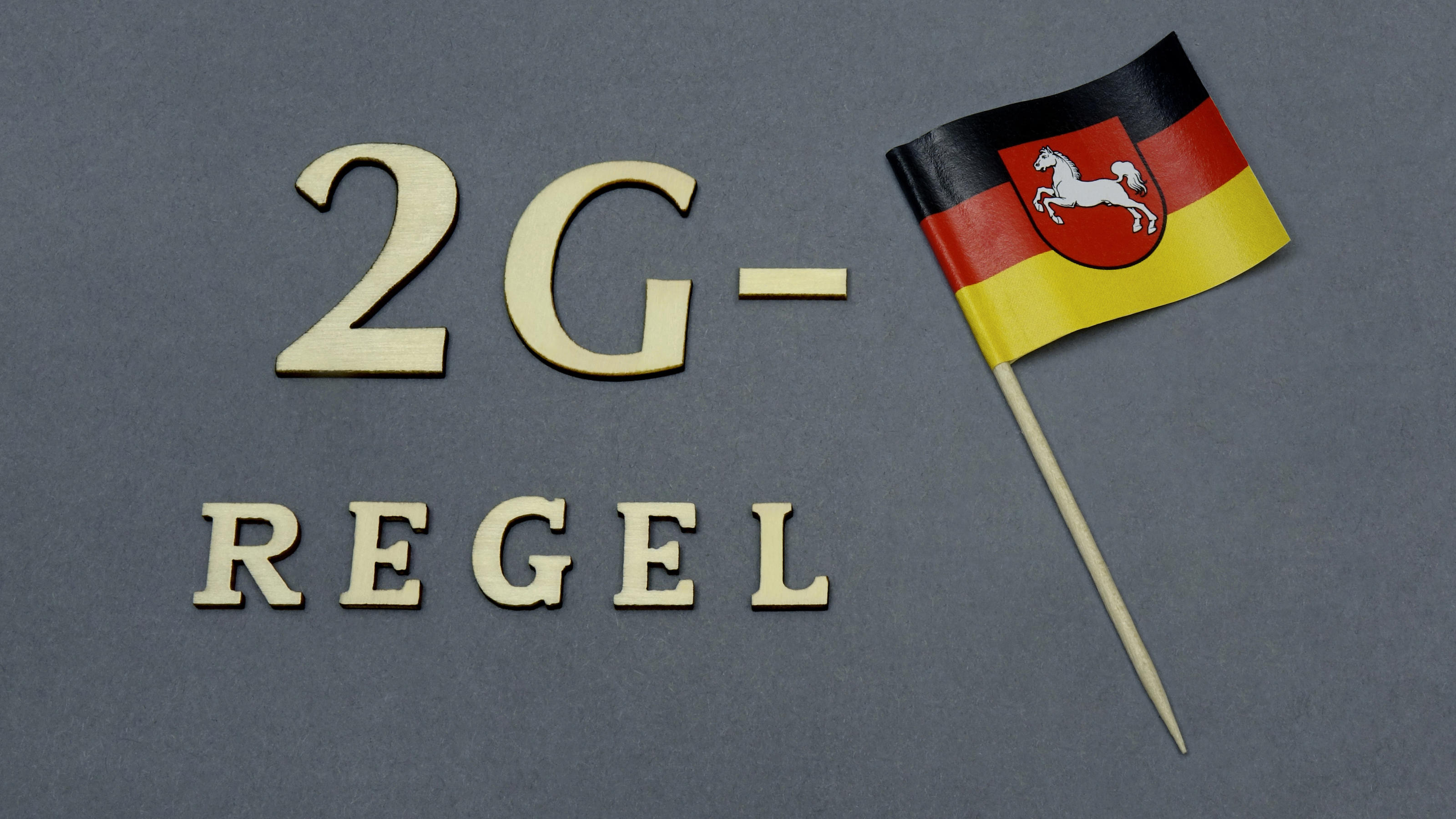 In diesen Bundesländern kommt 2G Neben dem Schriftzug 2G Regel befindet sich ein Faehnchen von Niedersachsen.