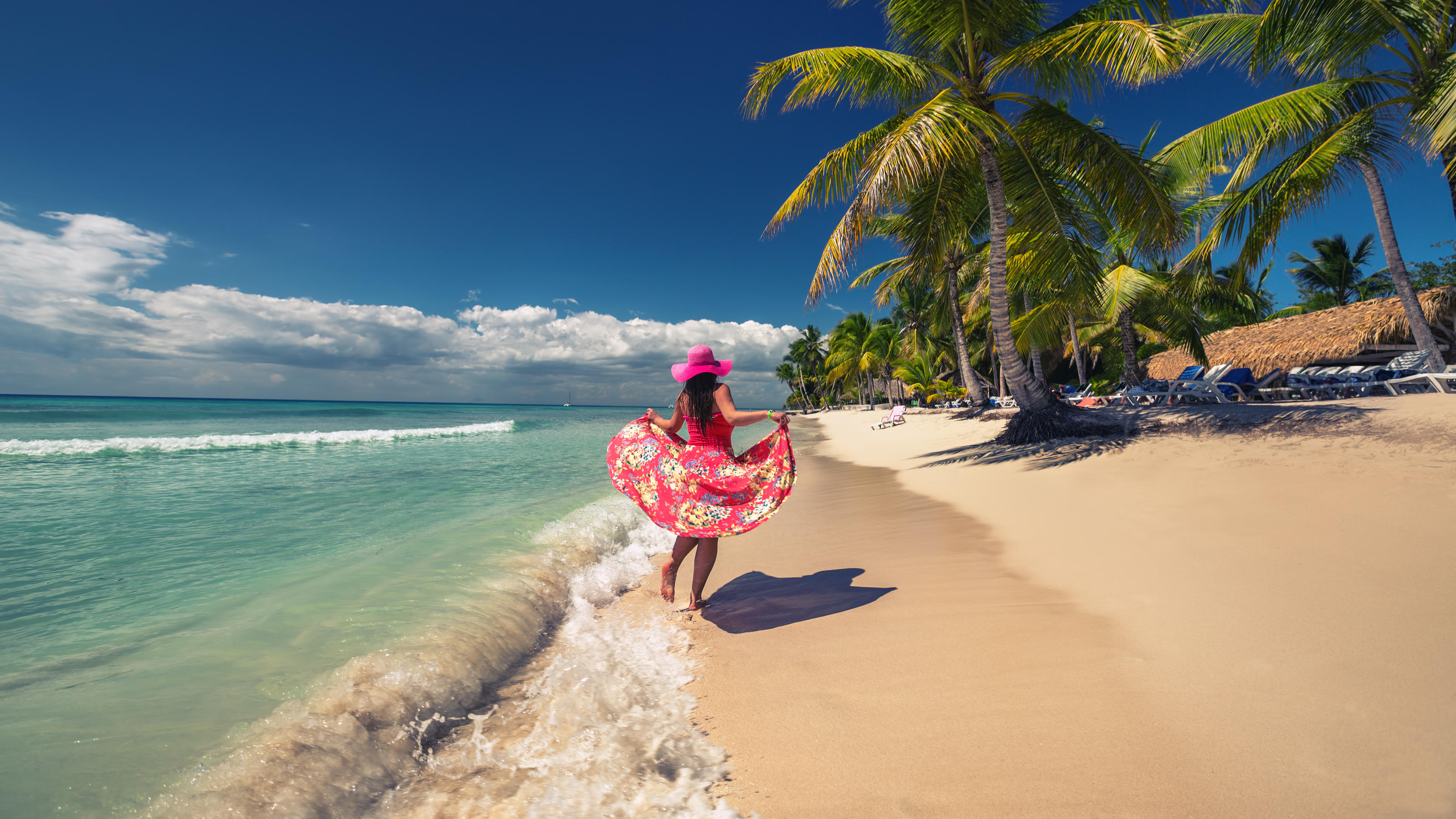 Knast nach Hotel-Beschwerde – wie Sie böse Urlaubsfallen vermeiden Eine Frau geht am Strand in der Karibik, in der Dominikanischen Republik, entlang.