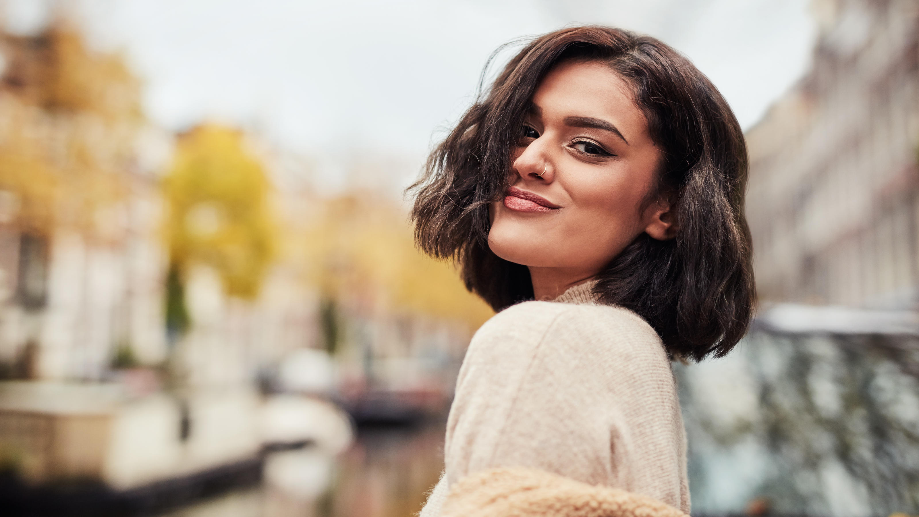 DER Frisurentrend im Herbst: Alle wollen den Jawline-Bob! Eine junge Frau grinst in die Kamera, sie trägt einen Kurzhaarschnitt.