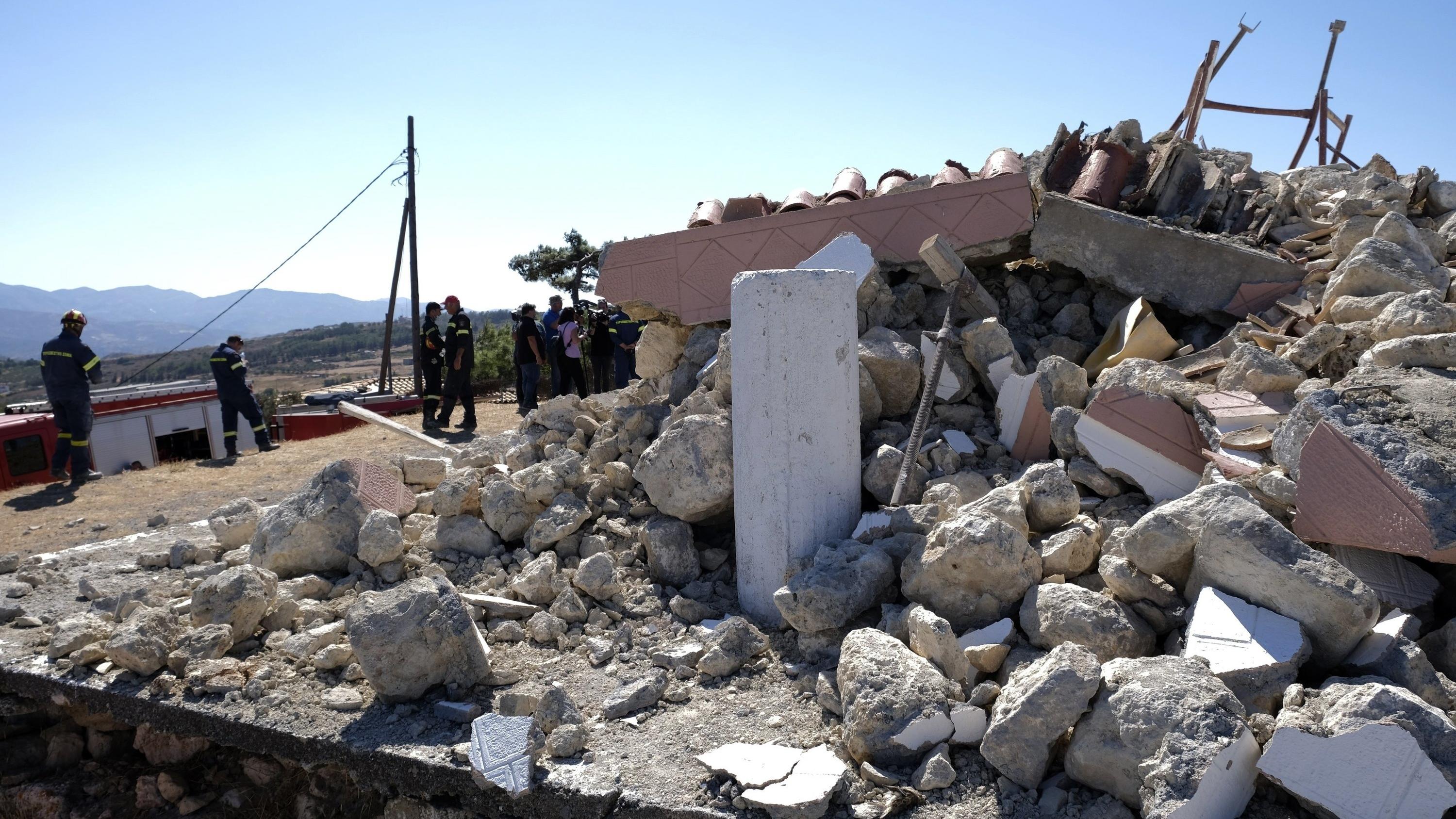 Griechenland: Starkes Nachbeben auf Kreta 27.09.2021, Griechenland, Arkalochori: Feuerwehrleute stehen neben der zerstörten griechisch-orthodoxen Kirche Profitis Ilias, nachdem das Dorf Arkalochori im Süden der Insel Kreta von einem Erdbeben erschüttert wurde. Mindestens ein Mensch ist bei d