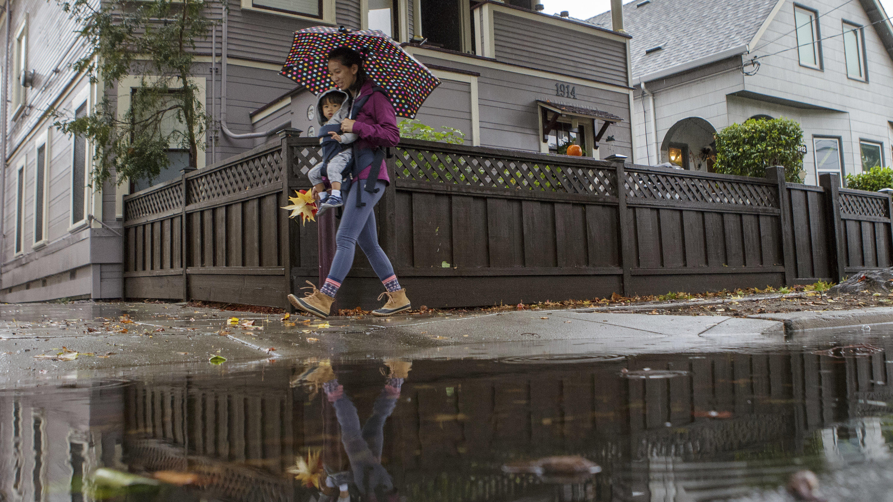Bomben-Zyklon bringt Erdrutsche, Überschwemmungen und Sturzfluten an US-Küste Allison Chan and son Ian Dimaano stroll past a puddle as rain falls in Alameda, Calif., on Sunday, Oct. 24, 2021. An atmospheric river storm, the strongest to hit the Bay Area in two years moved through the Bay Area on Sunday. (Anda Chu/Bay Area News