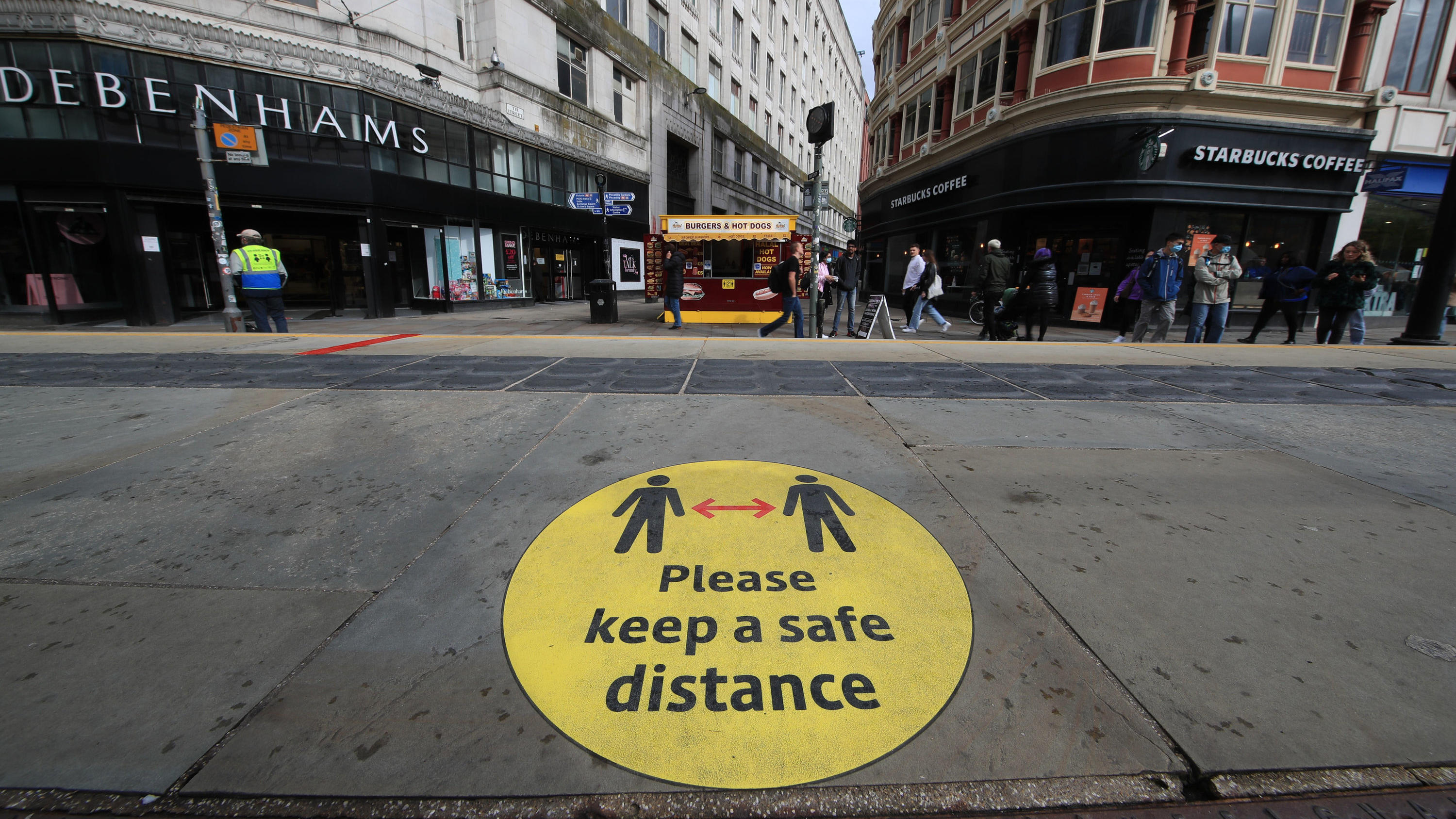Noch ansteckender: Neue Corona-Variante breitet sich aus Großbritannien, Manchester: Ein Leitschild auf dem Bürgersteig weist auf Beachtung der Social-Distancing-Maßnahmen hin. Britische Forscher empfehlen auf Grundlage einer neuen Studie, auch bei hohen Impfquoten Corona-Regeln beizub