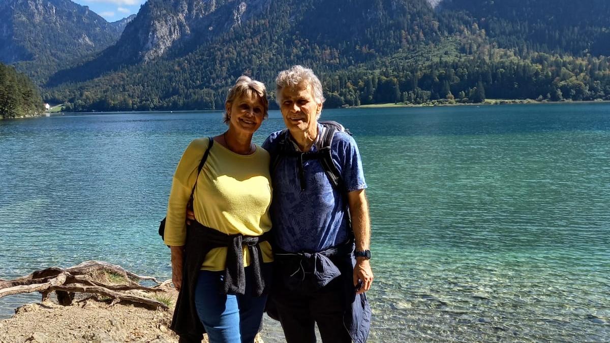 QR-Code-Panne am Flughafen? Wie Sie sich vorm Urlaubs-Aus schützen Mann und Frau, die im Tal vor See und Bergen stehen