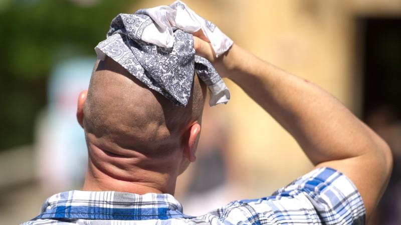 Hitzewelle Juli 2019: Als die Hitze Deutschland fest im Griff hatte ARCHIV - Ein Mann wischt sich am 02.08.2013 in Hannover (Niedersachsen) mit einem Stofftuch über den Kopf. 2013 sind alle denkbaren Wetterextrema aufgetaucht - ein Zusammenhang mit dem Klimawandel lässt sich nach Angaben der Meteorologen mit dem Wett