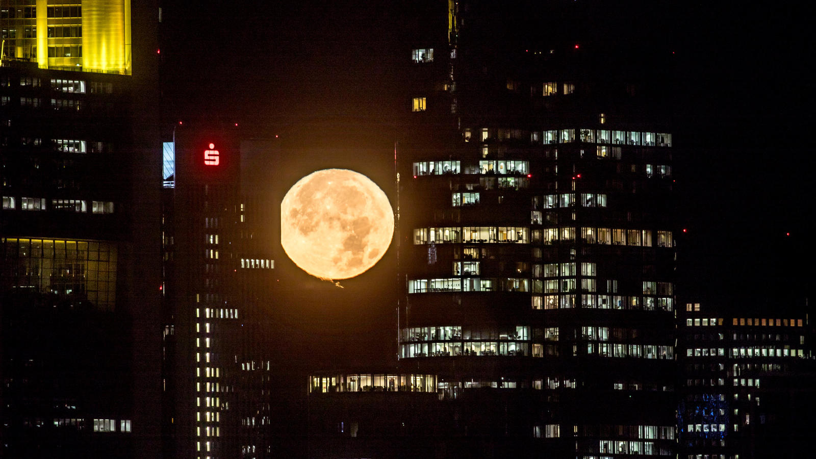 Supermond am 7./8. April 2020: Wann und wo der größte Vollmond des Jahres am besten zu sehen ist Der untergehende Mond strahlt am 14.11.2016 in Frankfurt am Main (Hessen) früh morgens hinter den Bankentürmen der Stadt. Der Mond kommt der Erde derzeit so nahe wie selten, wodurch er besonders groß erscheint. Foto: Frank Rumpenhorst/dpa +++(c) dpa