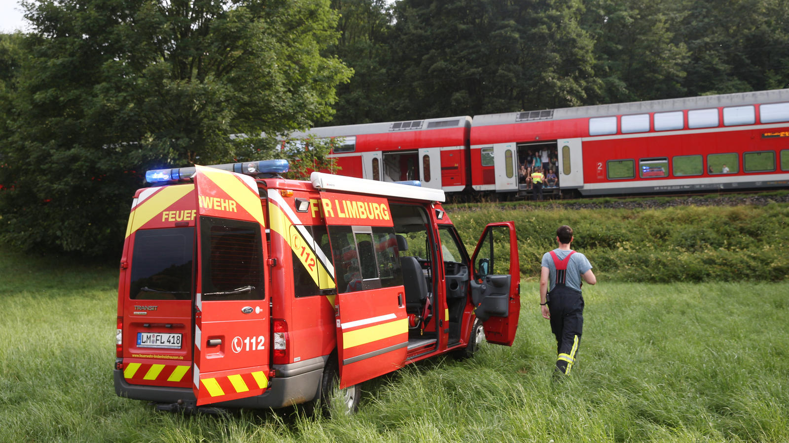 Heftige Gewitter im Westen: Bahngleise dicht, Zeltplätze geräumt, Behinderungen im Flugverkehr Ein Regionalzug steht bei Niederbrechen auf freier Strecke. Feuerwehrleute betreuen die Passagiere. Ein Baum war während eines Gewitters in die Oberleitung gestürzt und hatte den Zugverkehr unterbrochen.