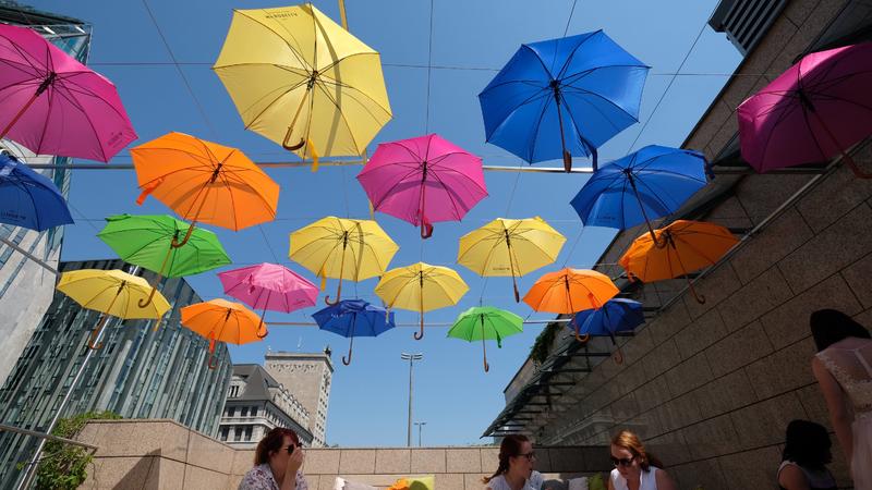 26.05.2018, Sachsen, Leipzig: Besucher eines Eiscafes sitzen auf dem Leipziger Augustusplatz unter farbigen Regenschirmen. Foto: Sebastian Willnow/dpa-Zentralbild/dpa +++ dpa-Bildfunk +++