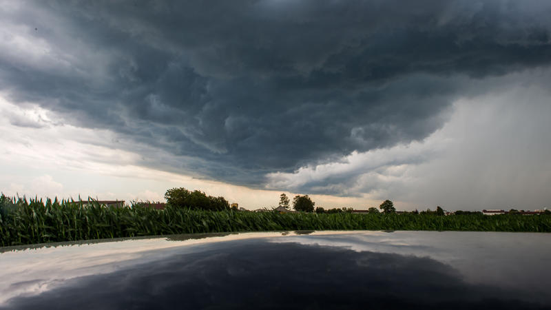 21.06.2018, Bayern, München: Eine Gewitterwolke spiegelt sich in einem Autodach Foto: Lino Mirgeler/dpa +++ dpa-Bildfunk +++