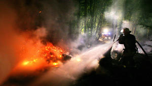 ARCHIV - 04.05.2007, Nordrhein-Westfalen, Sundern: Ein Feuerwehrmann löscht im Sauerland einen Waldbrand. Durch die Trockenheit steigt in Nordrhein-Westfalen die Waldbrandgefahr.  (zu dpa vom 03.07.2018) Foto: Julian Stratenschulte/dpa +++ dpa-Bildfunk +++