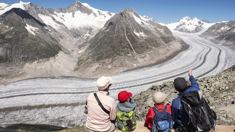 Wanderer machen auf dem Eggishorn (2.869 m) oberhalb Fiesch eine Pause und betrachten den Großen Aletschgletscher. 