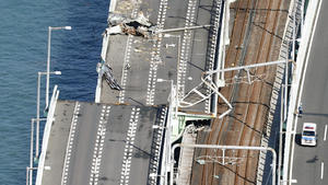 05.09.2018, Japan, Osaka: Diese Luftaufnahme zeigt eine beschädigte Brücke die den Kansai International Airport auf einer künstlichen Insel in der Osaka Bay mit dem Festland verbindet. Ein im Sturm abgetriebener Tanker war gegen die Brücke geprallt, die den Flughafen mit dem Festland verbindet. Die elf Personen an Bord des Schiffes blieben unverletzt. Foto: Hiroko Harima/kyodo/dpa +++ dpa-Bildfunk +++