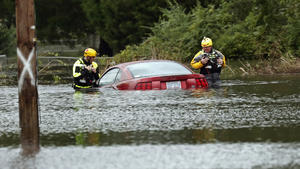 dpatopbilder - 15.09.2018, USA, New Bern: Mitglieder der Feuerwehr untersuchen auf einer überfluteten Straße ein halb unter Wasser stehendes Auto. Auf seinem Weg ins Landesinnere der USA bringt Wirbelsturm «Florence» gewaltige Wassermassen und Sturm mit sich. Weite Landstriche der Bundesstaaten North Carolina und South Carolina waren am Samstagmorgen (Ortszeit) überschwemmt. Foto: Chris Seward/AP/dpa +++ dpa-Bildfunk +++