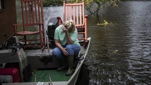 17.09.2018, USA, Trenton: Michelle Haddock stützt erschöpft ihren Kopf in die Hand, während sie Möbel aus ihrem überfluteten Haus in Sicherheit bringt. Foto: Travis Long/The News & Observer/dpa +++ dpa-Bildfunk +++