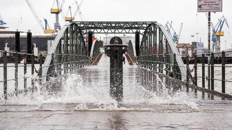 23.10.2018, Hamburg: Wasser schwappt während Hochwasser über eine Brücke am Fischmarkt. Sturmtief "Siglinde" lässt das Wasser über die Ufer treten