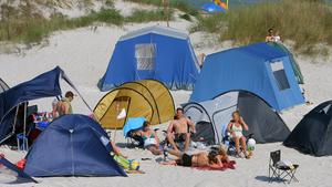 Im Regenbogen Camp Prerow (Kreis Nordvorpommern) auf der Ostseehalbinsel Fischland-Darß-Zingst haben sich Urlauber am Donnerstag (20.08.2009) in den Dünen niedergelassen. Das Camp erstreckt sich über zweieinhalb Kilometer. Das Besondere an der Anlage ist die Möglichkeit, direkt in den Dünen und am Strand zu campen. Im Regenbogen Camp Prerow gibt es u. a. 800 Stellplätze für Wohnwagen, Wohnmobile oder Zelte, neun Sanitärgebäude, einen SB-Markt mit Bäckerei und Restaurants. Foto: Bernd Wüstneck dpa/lmv +++(c) dpa - Bildfunk+++