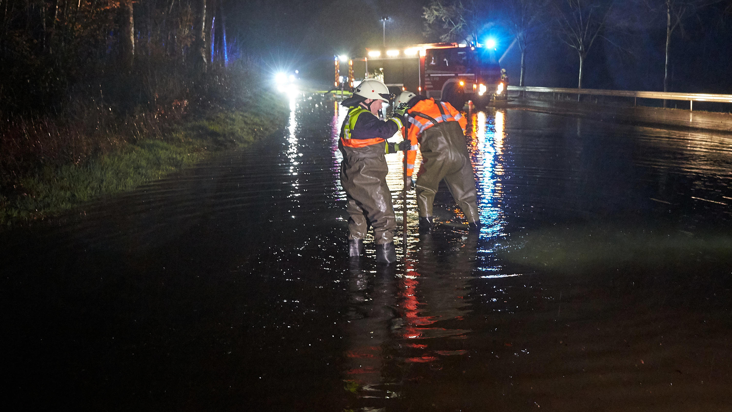 Dauerregen lässt Flüsse und Bäche über die Ufer treten 16.03.2019, Rheinland-Pfalz, Niederelbert: Feuerwehrleute versuchen nach einem Unwetter, mit Pumpen die überflutete Landesstrasse 327 wieder befahrbar zu machen. Nach starken Regenfällen sind rund um Montabaur rund 200 Helfer von Feuerwehr und THW im