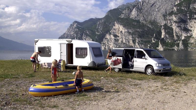Eine Familie campiert mit ihrem Wohnwagen an einem idyllisch gelegen See. Aufnahme vom 11.5.2000. Ein Urlaub mit dem Wohnwagen oder Caravan hat viele Vorteile: Mit dem Wohnwagen hat man sein Bett immer dabei und muss nicht im Hotel übernachten. Und a