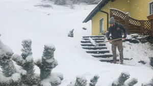 28.04.2019, Schweiz, St. Michael Im Lungau: Ein Mann räumt nach einem überraschenden Wintereinbruch den Schnee vor einem Haus weg. Foto: Franz Neumayr/APA/dpa +++ dpa-Bildfunk +++