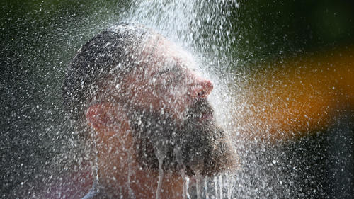25.07.2019, Baden-Württemberg, Freiburg: Alexander kühlt sich im Freibad unter einer Dusche ab. Eine neue Hitzewelle bringt Deutschland mit rekordverdächtigen Temperaturen zum Schwitzen. Foto: Patrick Seeger/dpa +++ dpa-Bildfunk +++
