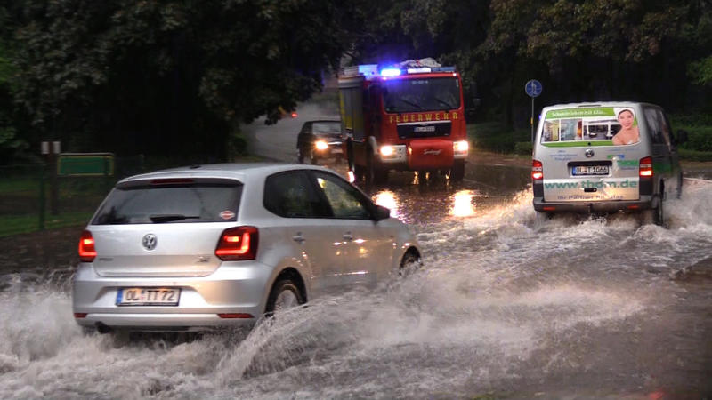 28.08.2019, Ganderkesee: Autos fahren über eine nach dem Starkregen überschwemmte Straße. Ein Unwetter hat am Mittwochabend in Delmenhorst und Umgebung einen Dauereinsatz der Feuerwehr ausgelöst. Foto: Nord-West-Media-TV/dpa +++ dpa-Bildfunk +++