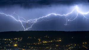 ARCHIV - 27.07.2019, Stuttgart: Blitze zucken des Nachts hinter der beleuchteten Stadt am Horizont, und schlagen nahe des Fernsehturms ein. (zu dpa: «Potzblitz: Mehr als 430 000 Blitze in Baden-Württemberg gemessen») Foto: Simon Adomat/dpa +++ dpa-Bildfunk +++