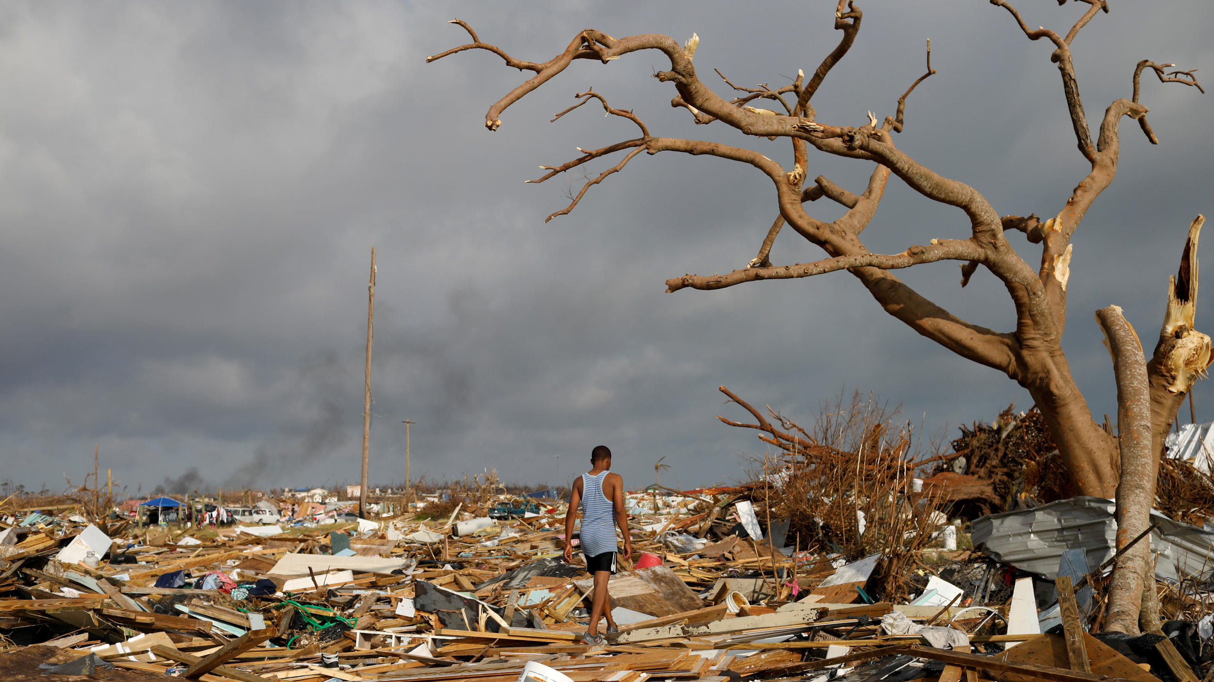 FILE PHOTO: A man walks among debris at the Mudd neighborhood, devastated after Hurricane Dorian hit the Abaco Islands in Marsh Harbour, Bahamas, September 6, 2019. REUTERS/Marco Bello/File Photo