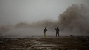 21.01.2020, Spanien, Barcelona: Ein Paar fotografiert die Wellen während eines Sturms in Barcelona. Schnee und Unwetter haben im Osten Spaniens Stromausfälle, Zugverspätungen und Rekordwellen ausgelöst. Foto: Emilio Morenatti/AP/dpa +++ dpa-Bildfunk +++