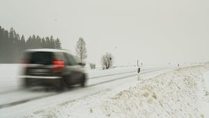 27.02.2020, Bayern, Leupoldsdorf: Ein Auto fährt bei dichtem Schneetreiben auf einer schneebedeckten Landstraße. Foto: Nicolas Armer/dpa +++ dpa-Bildfunk +++
